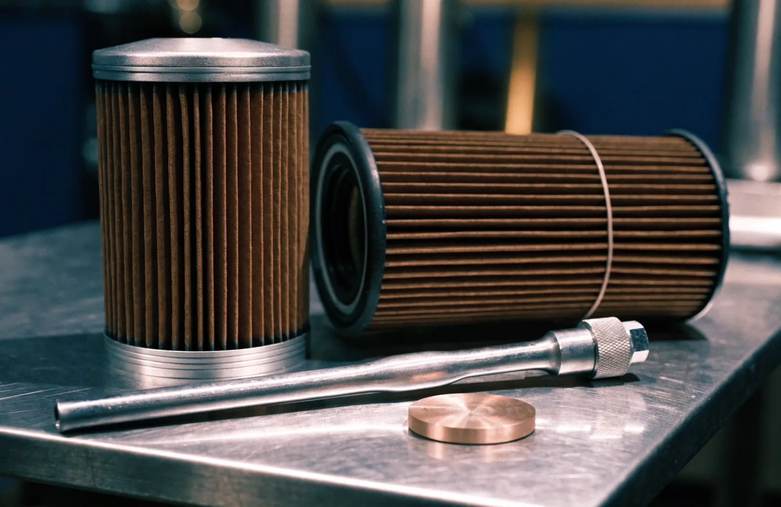Cartridge and spin-on oil filter elements with a torque wrench and crush washer on a shop bench