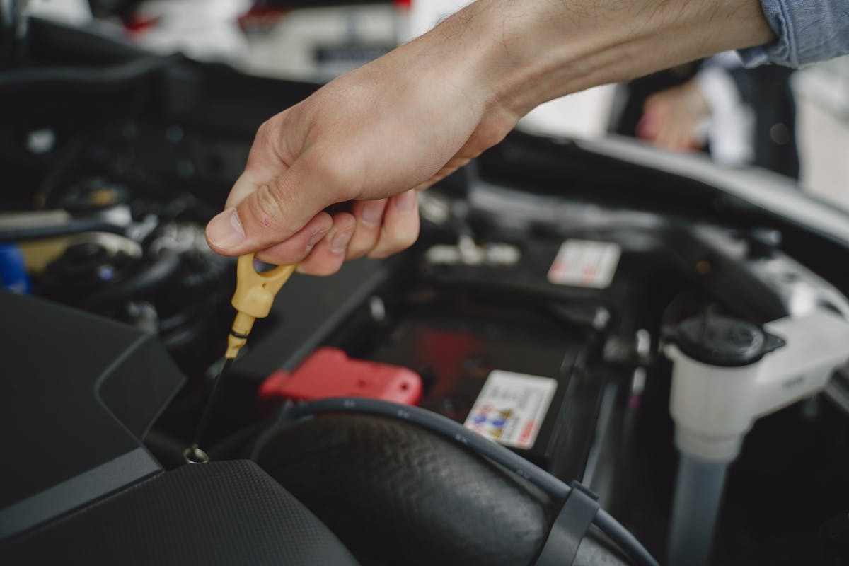 Technician checking an oil dipstick during a drive-thru oil change